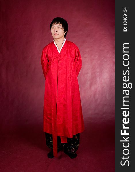 Korean man in a traditional dress on the red background.