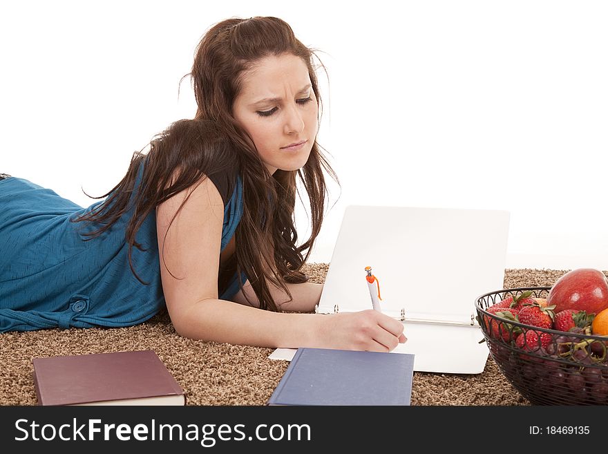 A woman is laying on the floor doing homework. A woman is laying on the floor doing homework.