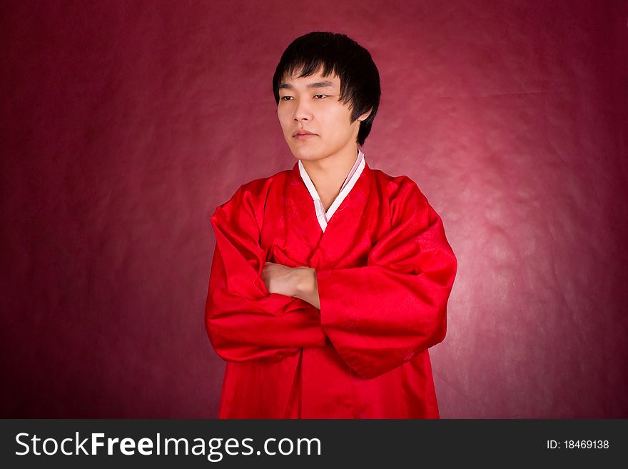 Korean man in a traditional dress on the red background.