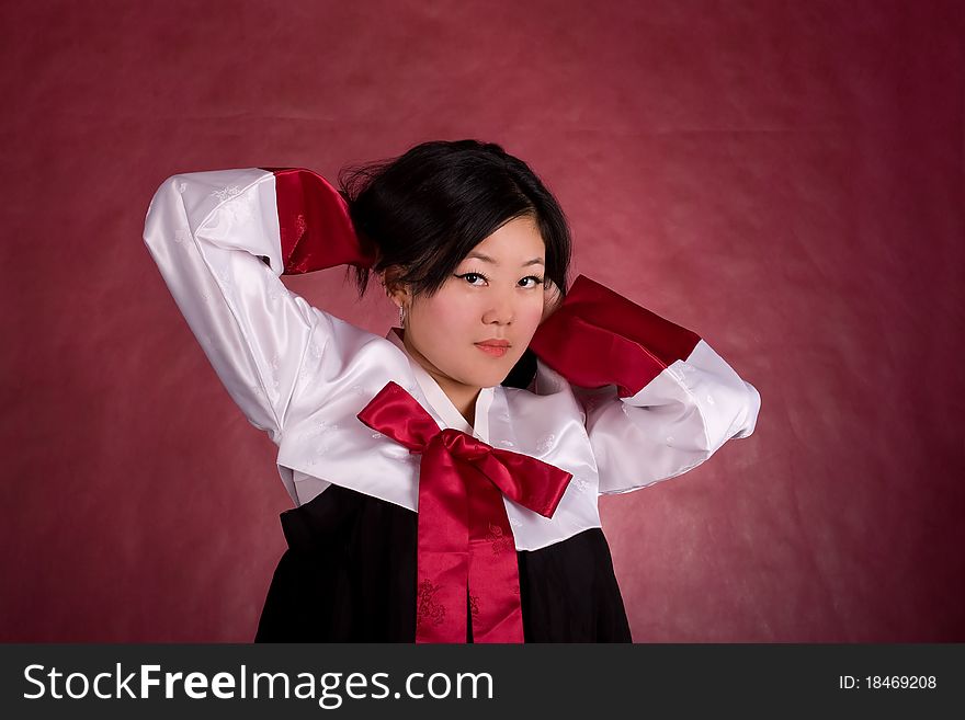 Elegant chinese model in traditional dress on the red background.