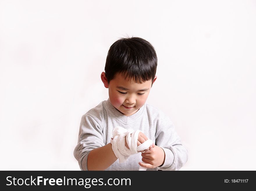 Picture of a little chinese boy winding bandage on hand by himself