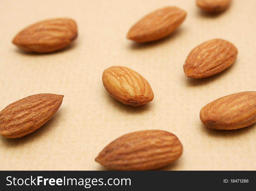 Close up for pile of almond nuts over brown background.