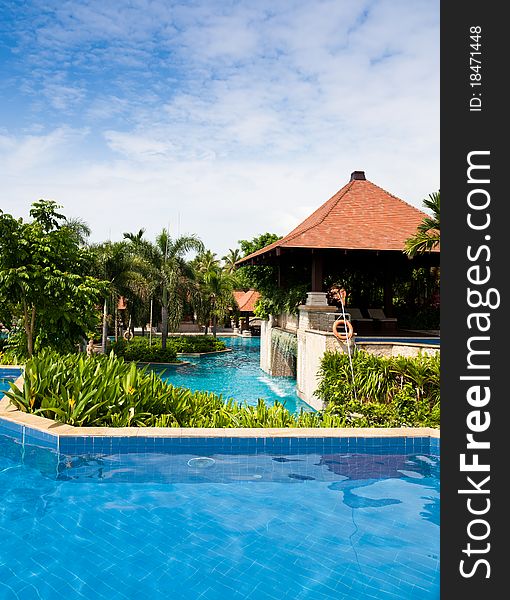 Swimming pool in tropical garden with flowers and trees at the poolside. Swimming pool in tropical garden with flowers and trees at the poolside