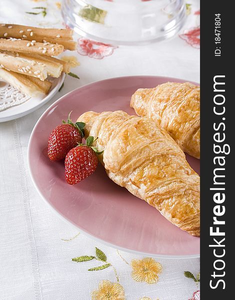 Croissants for breakfast served with strawberry and cheese stick. Croissants for breakfast served with strawberry and cheese stick