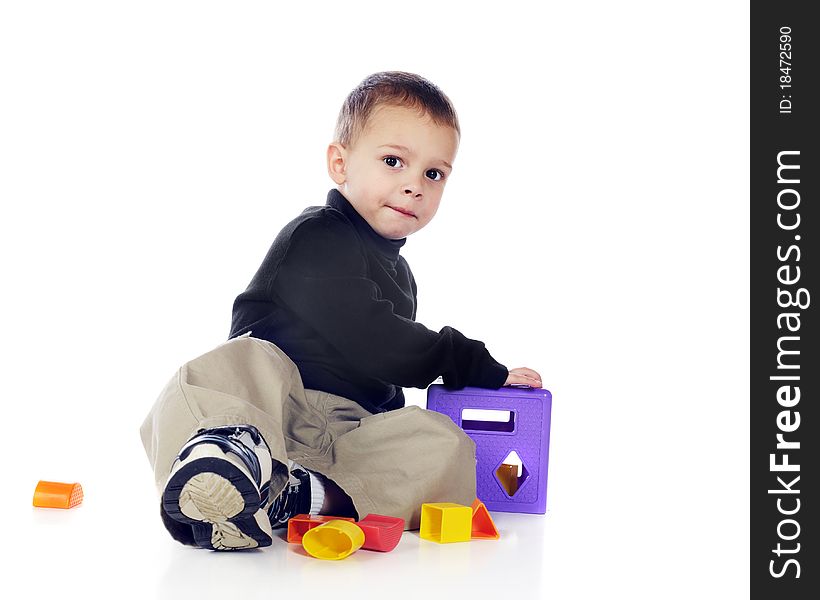 An adorable preschooler playing with a colorful 3-D puzzle. Isolated on white. An adorable preschooler playing with a colorful 3-D puzzle. Isolated on white.