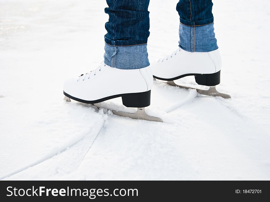 Woman legs in white ice skates