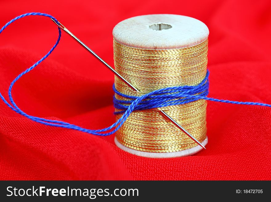 Thread and needle on a red background. Thread and needle on a red background