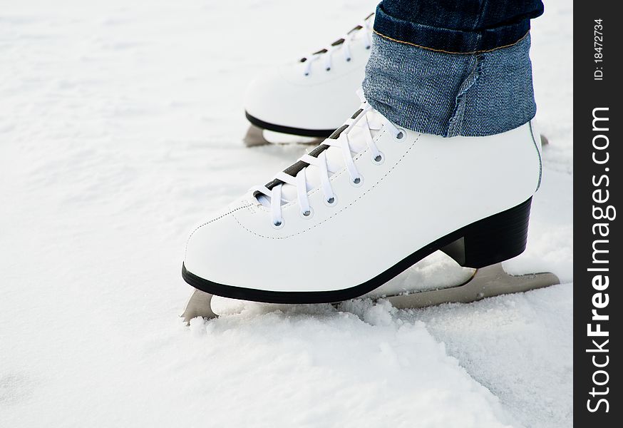 Woman legs in white ice skates