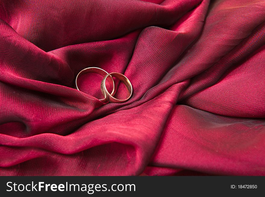 Two gold wedding rings on the red