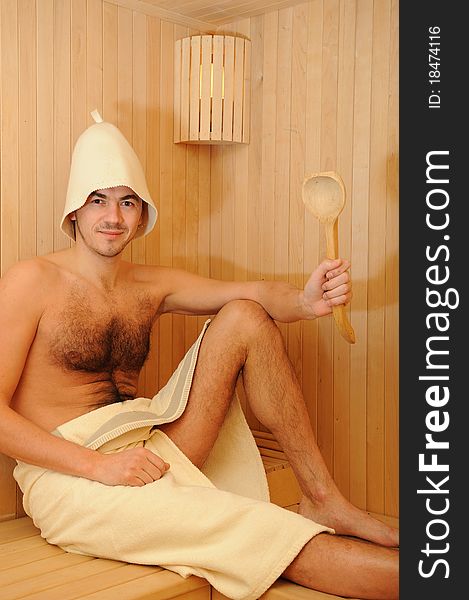 Young Man Relaxing In A Russian Wooden Sauna