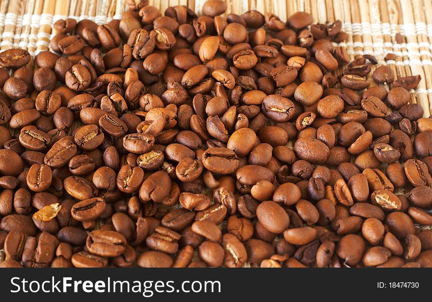 Freshly roasted coffee beans on bamboo placemat