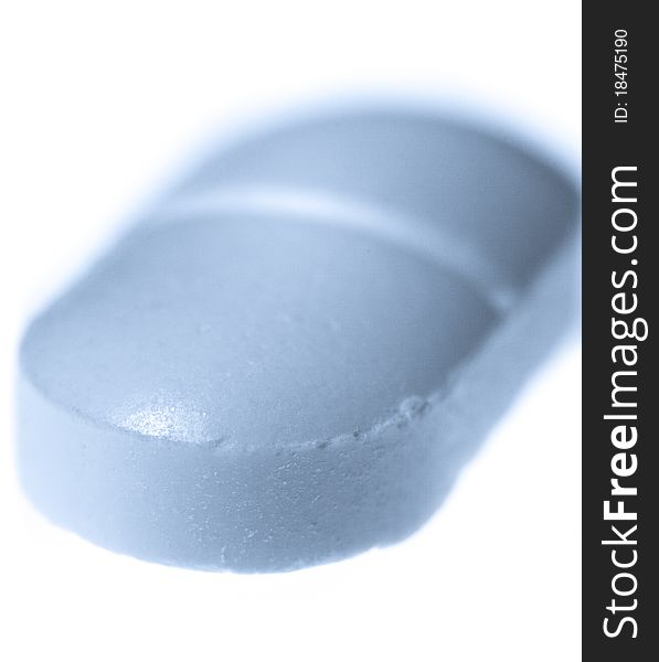 Extreme macro close-up of a pill isolated on white with blue toning. Extreme macro close-up of a pill isolated on white with blue toning