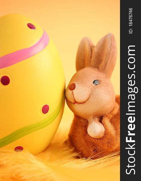 Easter bunny with colored eggs on yellow background