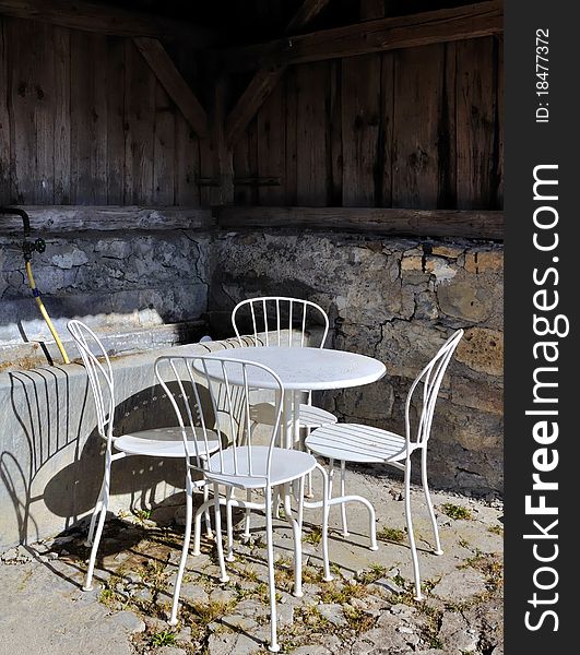 Barn sheltering a garden chairs and table. Barn sheltering a garden chairs and table