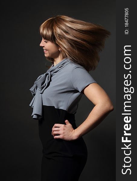 Portrait of young beauty woman with fluttering hair over dark background