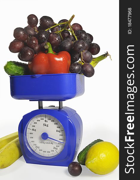 Fruit and vegetables on scales. It is isolated on a white background