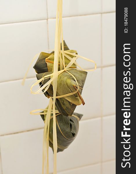 A bunch of Chinese meat dumplings wrapped in bamboo leaf.