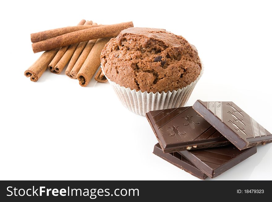 Chocolate muffin on a white background, close cinnamon sticks and chocolate