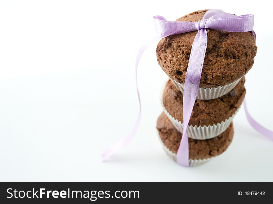 Chocolate Muffins tied with purple ribbon on a white background