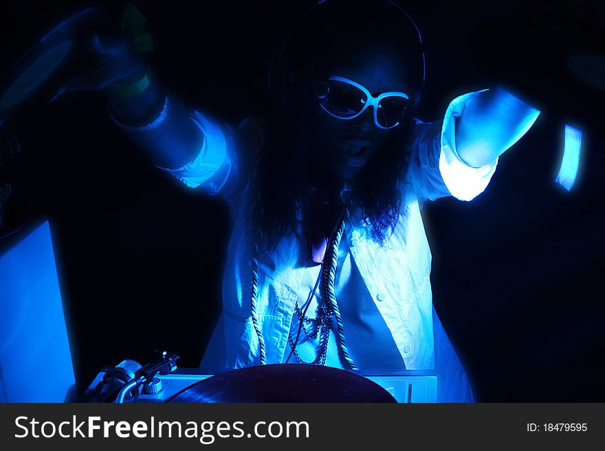 Cool afro american DJ in action under UV blue light