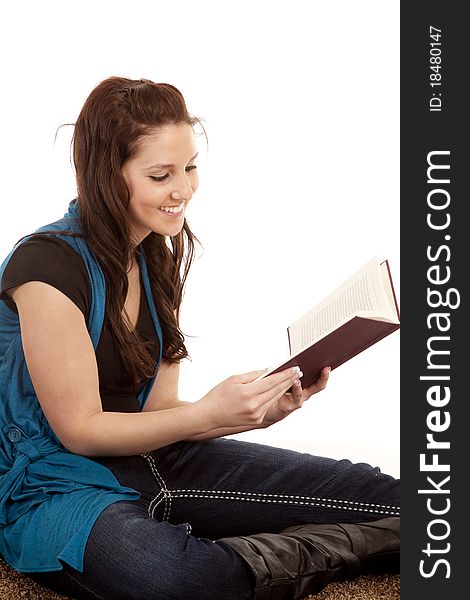 A woman is sitting with a book and looks happy. A woman is sitting with a book and looks happy.
