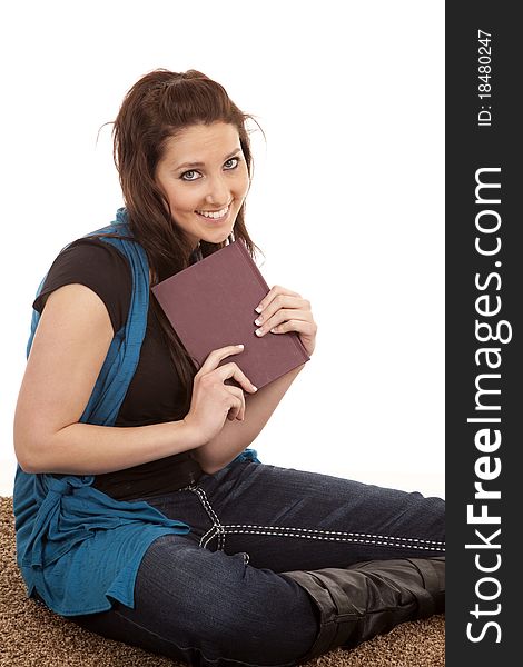 Woman sitting on floor holding book