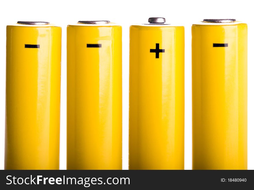 Four yellow batteries with plus and minus standing. Four yellow batteries with plus and minus standing