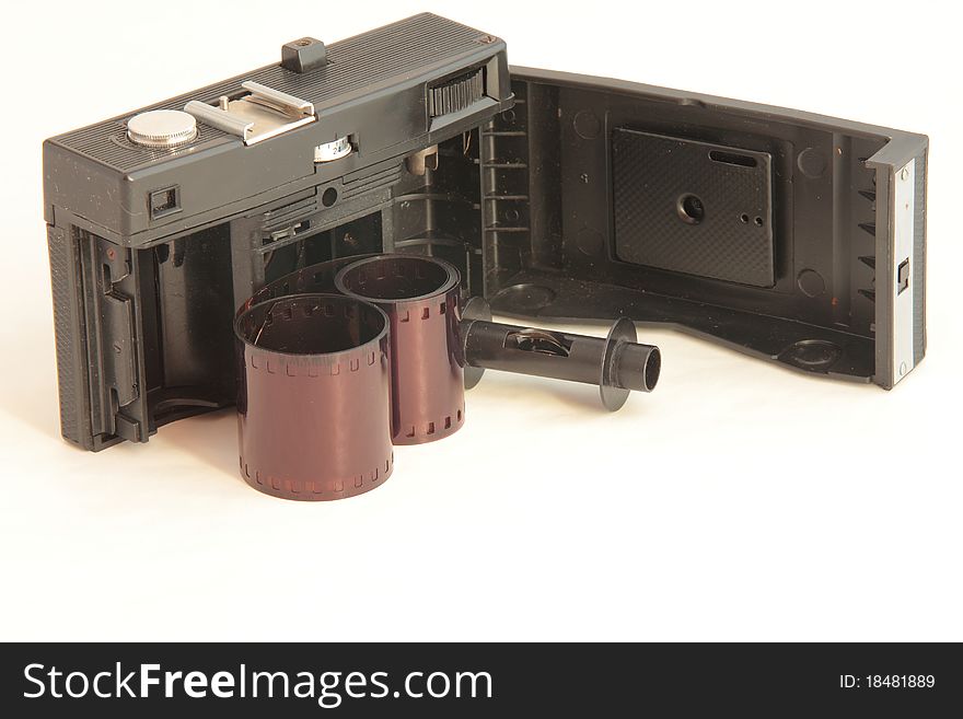 An old camera with open back with film on the white background
