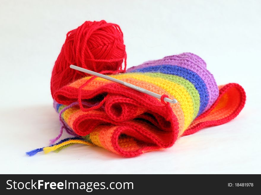 Knitting a colorful scarf on the white background