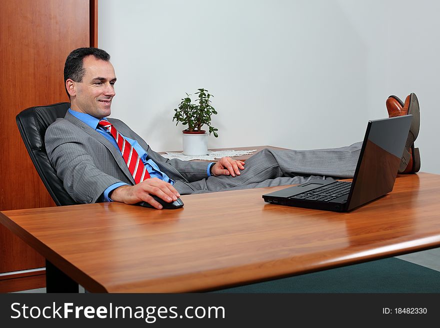 Successful businessman looking at computer how his earnings grow.