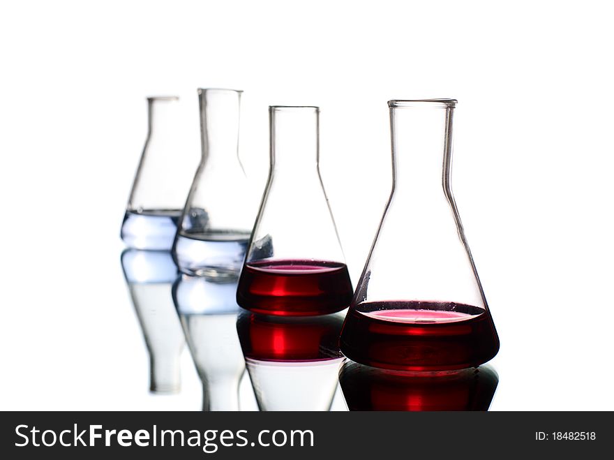 Laboratory flasks with liquid. White background. Studio shot. Laboratory flasks with liquid. White background. Studio shot.