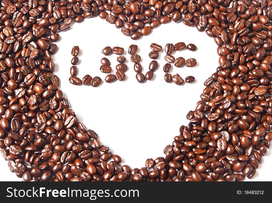 Heart from brown coffee beans and word of love on white background