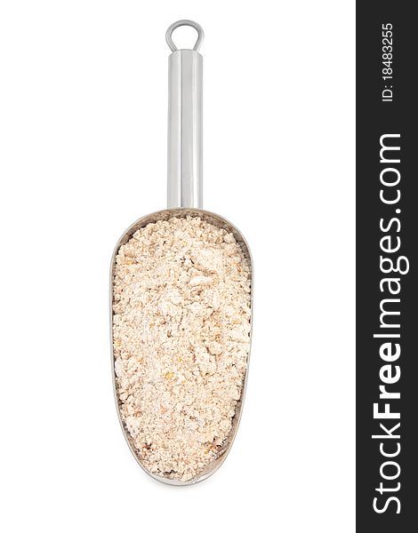 Wholegrain flour in a stainless steel metal scoop over white background.