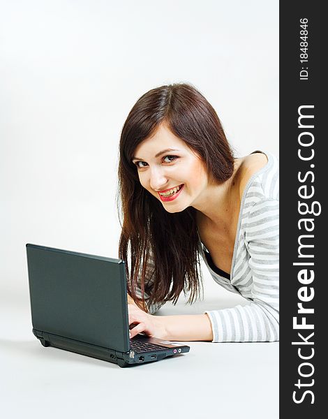 Girl with a laptop on a gray background. Girl with a laptop on a gray background