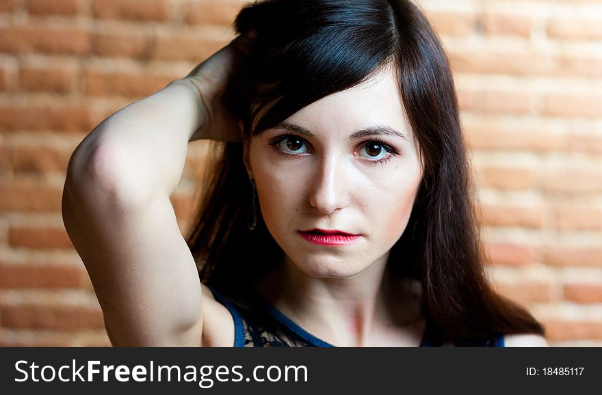 Portrait of a close-up beautiful girl on a background of brick wall. Portrait of a close-up beautiful girl on a background of brick wall