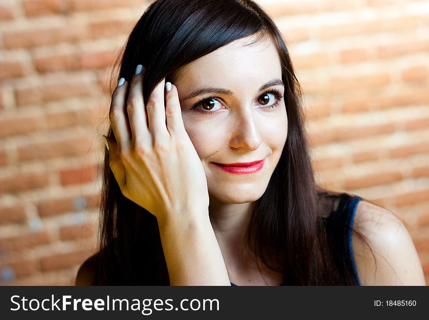 Portrait of a close-up beautiful girl on a background of brick wall. Portrait of a close-up beautiful girl on a background of brick wall