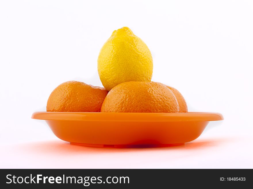 Fruit on an orange plate on a white background