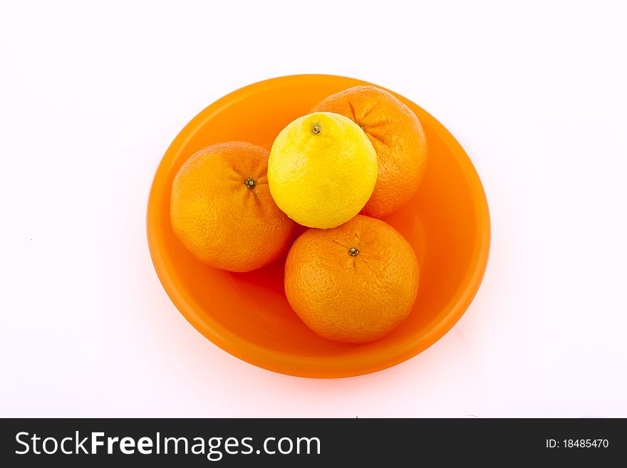 Fruit on an orange plate on a white background