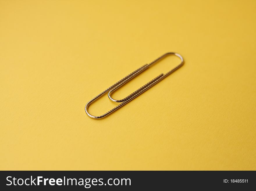 Wire paperclip against a yellow background