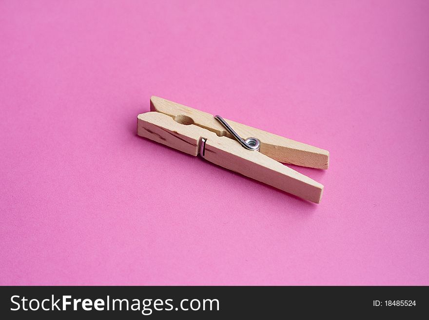 Wooden peg against a pink background