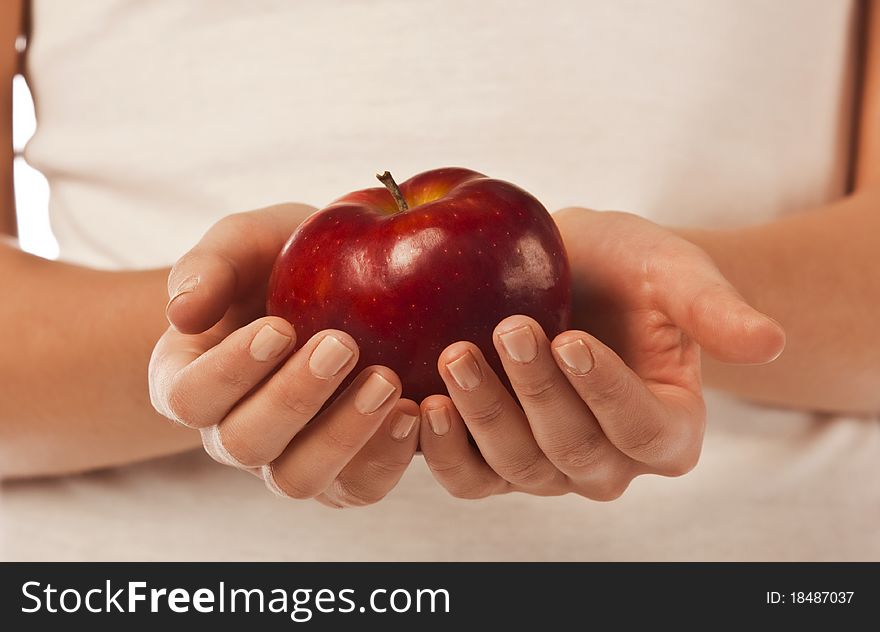 Fresh red apple in a woman hand close up