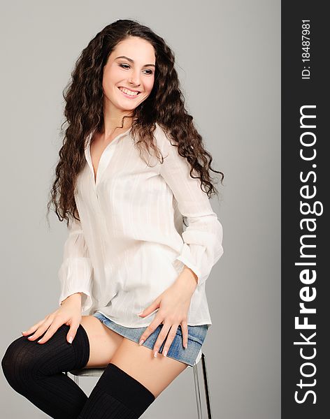 Smiling beautiful young brunet woman in white shirt studio shoot. Smiling beautiful young brunet woman in white shirt studio shoot