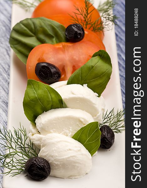 Photo of delicious tomatoe and mozzarella salad with black olives. Photo of delicious tomatoe and mozzarella salad with black olives