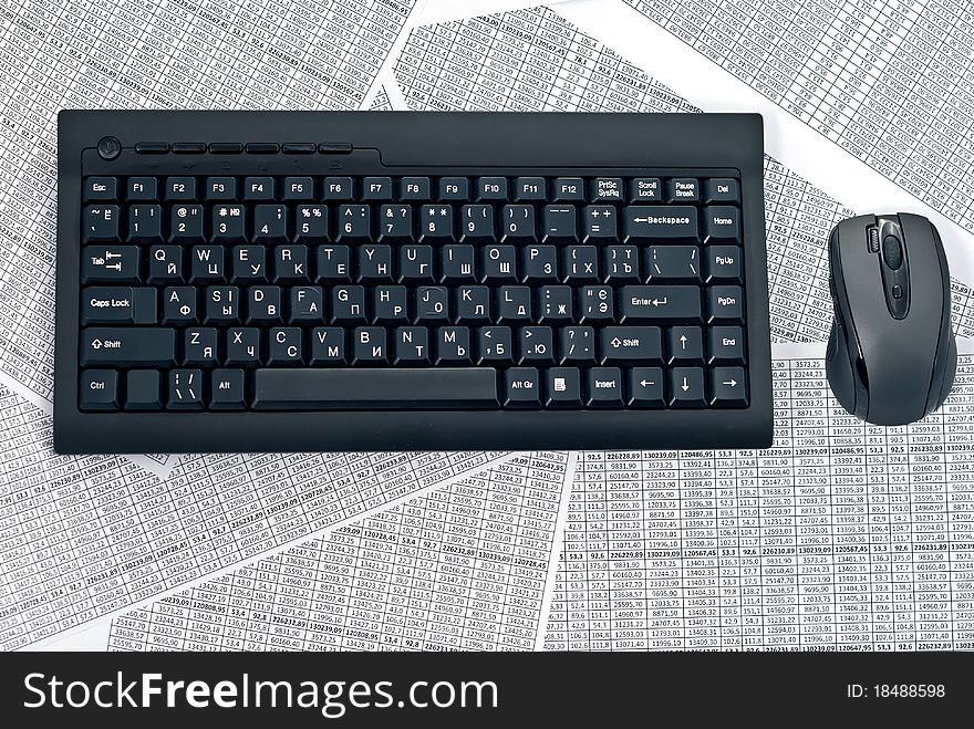 Black keyboard and mouse on a spreadsheets. Black keyboard and mouse on a spreadsheets.