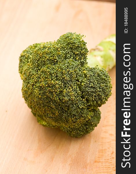 Photo of fresh raw broccoli on wooden chopping board