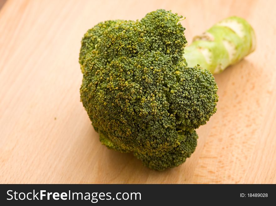 Photo of fresh raw broccoli on wooden chopping board