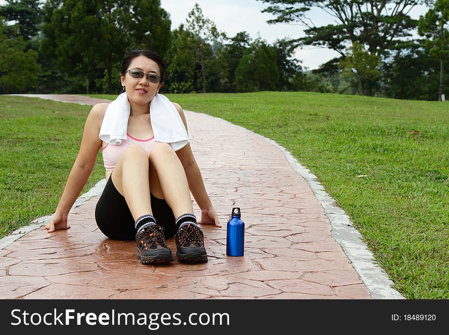 An Asian woman relaxing after a workout session. An Asian woman relaxing after a workout session