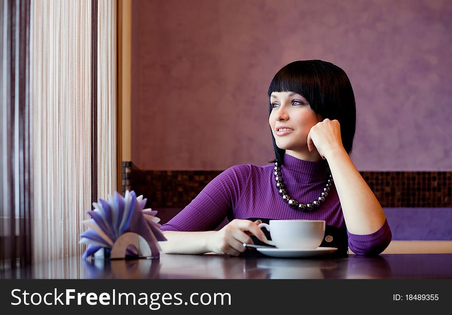 Girl in cafe with coffee cup smiling