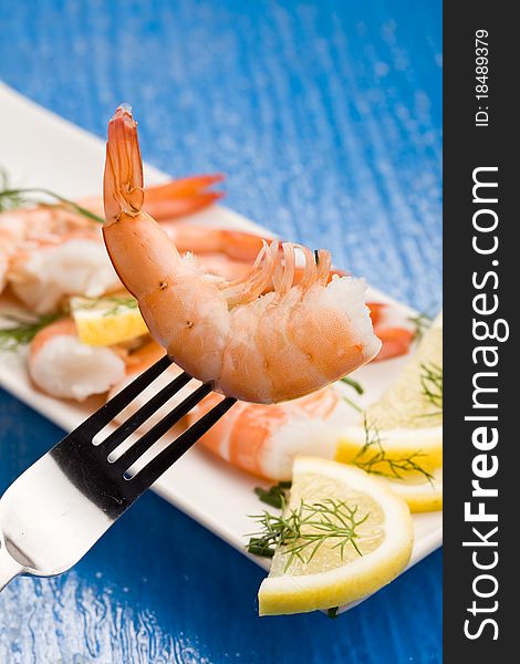 Photo of delicious raw prawns with lemon slices and onions on white plate. Photo of delicious raw prawns with lemon slices and onions on white plate