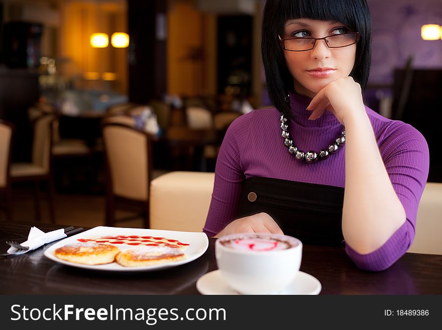 Girl sitting in cafe with cup of coffee and food. Girl sitting in cafe with cup of coffee and food